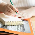 Людина пише олівцем у блокноті
