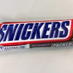 Шоколадний батончик Snickers в обгортці на столі