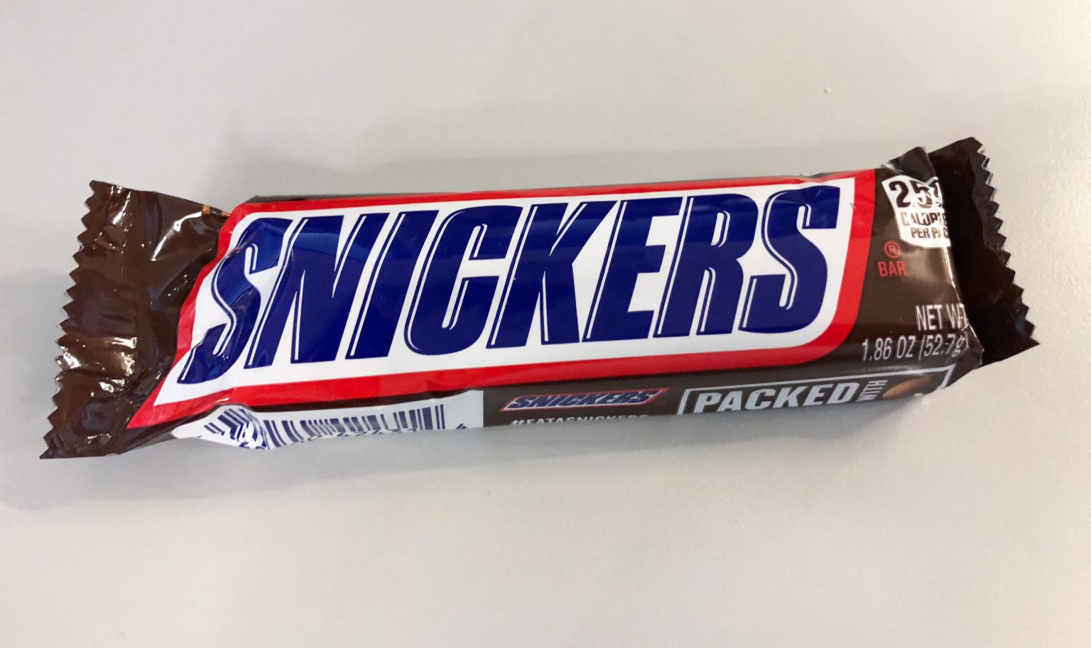 Шоколадний батончик Snickers в обгортці на столі