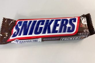 Шоколадний батончик Snickers в обгортці на столі
