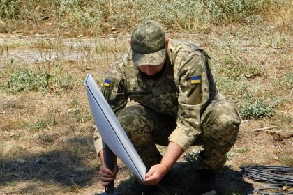 Військовий Сил підтримки ЗСУ встановлює термінал Starlink